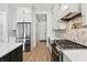 Spacious kitchen with stainless steel appliances, stone backsplash, sleek white cabinets, and hardwood floors at 5123 Oak Ridge Pl, Columbus, IN 47201