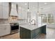 Bright, open kitchen featuring a large island with a sink, stainless steel appliances, and elegant white cabinetry at 5123 Oak Ridge Pl, Columbus, IN 47201