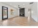 Modern living room featuring a black fireplace, fan, light floors, and black framed windows and door at 5123 Oak Ridge Pl, Columbus, IN 47201
