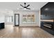 Open concept living room featuring a fireplace, ceiling fan, and an open view into the kitchen at 5123 Oak Ridge Pl, Columbus, IN 47201