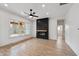 Modern living room featuring a black fireplace, fan, light floors, and large windows at 5123 Oak Ridge Pl, Columbus, IN 47201