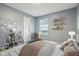 This bedroom features calming blue walls, carpet flooring, natural light, and decor shelves at 5150 Bramwell Ln, Whitestown, IN 46075