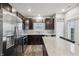 Stylish kitchen with stainless steel appliances, dark cabinetry, a kitchen island, and a bright window at 5150 Bramwell Ln, Whitestown, IN 46075