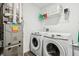 Well-lit laundry room with modern washer and dryer, plus overhead storage at 5150 Bramwell Ln, Whitestown, IN 46075