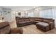 Spacious living room with wood floors and a large sofa, leading to the modern kitchen at 5150 Bramwell Ln, Whitestown, IN 46075
