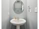 Cozy powder room features a pedestal sink, oval mirror, and clean, simple decor with blue walls at 5150 Bramwell Ln, Whitestown, IN 46075