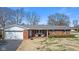 Charming brick home featuring an attached garage and inviting front porch at 5240 Magnolia Dr, Columbus, IN 47203