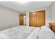 Bedroom with gray carpet and comforter, view of closet and adjoining room at 5453 Happy Hollow # 73, Indianapolis, IN 46268
