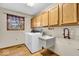 Functional laundry room with washer, sink, and overhead storage at 5453 Happy Hollow # 73, Indianapolis, IN 46268