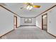 Expansive living room featuring neutral carpet, ceiling fan, and warm wood trim at 5453 Happy Hollow # 73, Indianapolis, IN 46268
