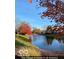 Picturesque view of a community pond with mature trees, offering a peaceful and scenic outdoor space at 5453 Happy Hollow # 73, Indianapolis, IN 46268