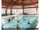 Indoor salt water pool with light coming through multiple windows and wooden beams at 5453 Happy Hollow # 73, Indianapolis, IN 46268