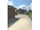 View of the detached garage, long driveway, and partially brick home at , Indianapolis, IN 46203