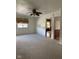 Spacious living room with plush carpeting, a ceiling fan, and a window with a view of the neighborhood at , Indianapolis, IN 46203