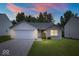 Charming single-story home featuring a brick facade, attached garage, and well-manicured lawn at dusk at 5842 Minden Dr, Indianapolis, IN 46221