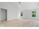 Bright, open living room featuring modern light fixtures, light wood floors, and three windows at 5842 Minden Dr, Indianapolis, IN 46221