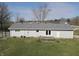 A view of the back of the house with sliding glass doors and small deck, with a large yard at 589 S 100 W, Franklin, IN 46131