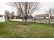 Backyard view with a tall leafless tree and green lawn surrounded by wooden fences at 6145 Crystal View Dr, Indianapolis, IN 46237