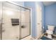 Bathroom featuring a frosted glass shower, toilet and blue rug on the neutral tile flooring at 6145 Crystal View Dr, Indianapolis, IN 46237