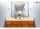 Bright bathroom featuring a wood vanity with a marble countertop, a mirror, and light blue walls at 6145 Crystal View Dr, Indianapolis, IN 46237
