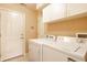 Functional laundry room with a white washer and dryer and white cabinets for ample storage at 6145 Crystal View Dr, Indianapolis, IN 46237