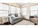 A bright sunroom with hardwood floors with a gray sofa, multiple windows, and vaulted ceiling at 6145 Crystal View Dr, Indianapolis, IN 46237