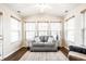 A bright sunroom with hardwood floors with a gray sofa, multiple windows, and vaulted ceiling at 6145 Crystal View Dr, Indianapolis, IN 46237