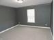 This carpeted bedroom features modern gray walls, white trim, and a window with blinds at 6418 W Oxford Ln, McCordsville, IN 46055