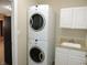 Laundry room with stacked washer and dryer and cabinet-lined wash basin at 6418 W Oxford Ln, McCordsville, IN 46055