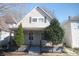 Charming house featuring a cozy front porch and meticulously landscaped yard with vibrant evergreens at 657 Birch Ave, Indianapolis, IN 46221