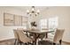 Bright dining room features a modern chandelier and a rustic wood table at 6733 Dorchester Dr, Zionsville, IN 46077