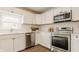 View of modern kitchen with stainless appliances, white cabinets, marble counters, and a window at 6733 Dorchester Dr, Zionsville, IN 46077