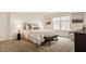 Bright main bedroom with plush carpet features a tufted headboard, side tables, and art at 6733 Dorchester Dr, Zionsville, IN 46077