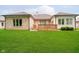 Spacious backyard featuring a well-kept lawn, brick accents, and a wooden deck at 7271 Catboat Ct, Fishers, IN 46038