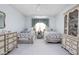 Light bedroom featuring twin beds with floral bedding, pale blue walls, and carpet at 7349 Castleton Farms N Dr, Indianapolis, IN 46256