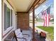 A quaint front porch with brick facade and comfortable seating, great for enjoying a quiet afternoon at 7349 Castleton Farms N Dr, Indianapolis, IN 46256