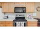 Modern kitchen details including stainless steel appliances, wood cabinetry, and white tile backsplash at 7349 Castleton Farms N Dr, Indianapolis, IN 46256