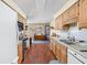 Bright kitchen with an open layout, wood cabinets, and a view into the dining area at 7349 Castleton Farms N Dr, Indianapolis, IN 46256