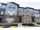 Modern townhome featuring mixed material facade with brick and gray siding, complemented by neat landscaping at 8194 Bostic Ct, Fishers, IN 46038
