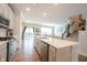 Modern kitchen showcasing an island with seating, stainless steel appliances, hardwood floors, and natural light at 8194 Bostic Ct, Fishers, IN 46038