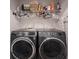 Convenient laundry room with modern front-load washer and dryer, plus ample shelving at 8194 Bostic Ct, Fishers, IN 46038
