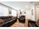 Spacious living room with hardwood floors and an inviting layout with dark leather furniture and bright windows at 8194 Bostic Ct, Fishers, IN 46038