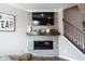 Living room fireplace with tiled wall and modern decor, complemented by staircase at 8194 Bostic Ct, Fishers, IN 46038