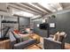 Finished basement features gray walls, built-in shelving, a large TV, comfortable seating, and exercise equipment at 827 N Park Ave, Indianapolis, IN 46202