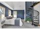Cozy bedroom with blue accent wall, carpet, and spiral stairs at 827 N Park Ave, Indianapolis, IN 46202