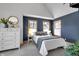 Cozy bedroom featuring blue accent wall, carpet, dresser, and natural light from windows at 827 N Park Ave, Indianapolis, IN 46202
