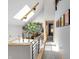 Bright hallway with skylight, rail, and open floorplan showcasing a large plant at 827 N Park Ave, Indianapolis, IN 46202