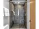 Modern tiled shower enclosure with glass doors, showerhead, and contemporary fixtures at 827 N Park Ave, Indianapolis, IN 46202