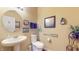 Charming powder room featuring a pedestal sink, round mirror, and nautical-themed decor at 8536 Blue Marlin Dr, Indianapolis, IN 46239
