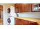 Convenient laundry room with stacked washer and dryer, featuring ample wooden cabinet space and countertop at 8536 Blue Marlin Dr, Indianapolis, IN 46239